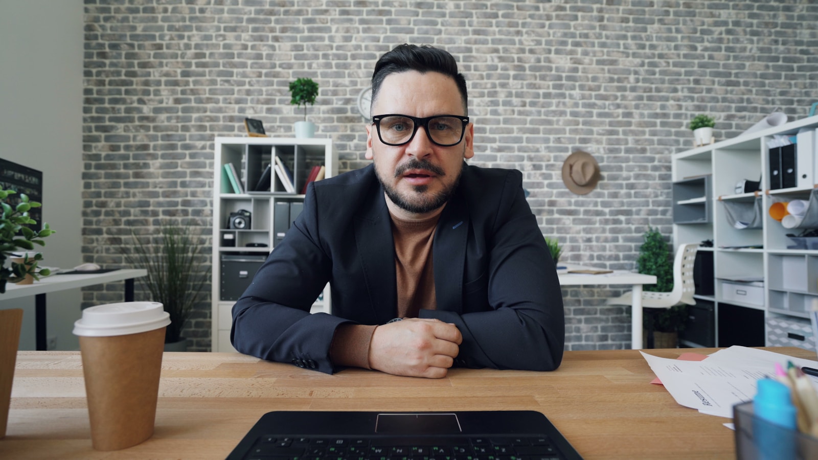 a man sitting at a table in front of a laptop