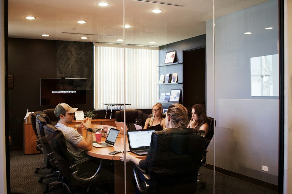 people sitting near table with laptop computer